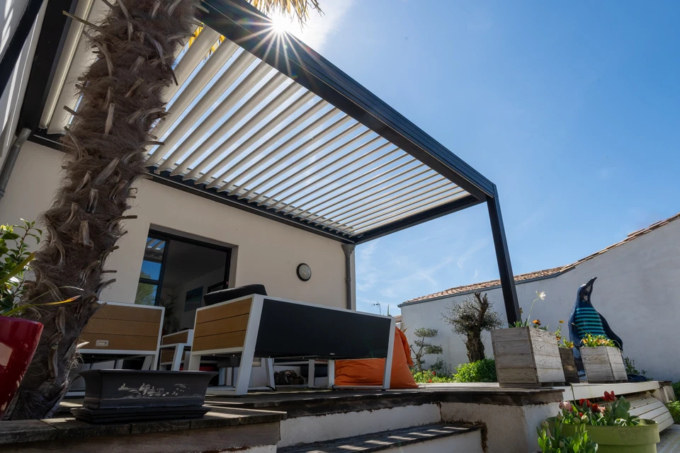 Pergola bioclimatique en aluminium anthracite, structure autoportante avec lames orientables motorisées