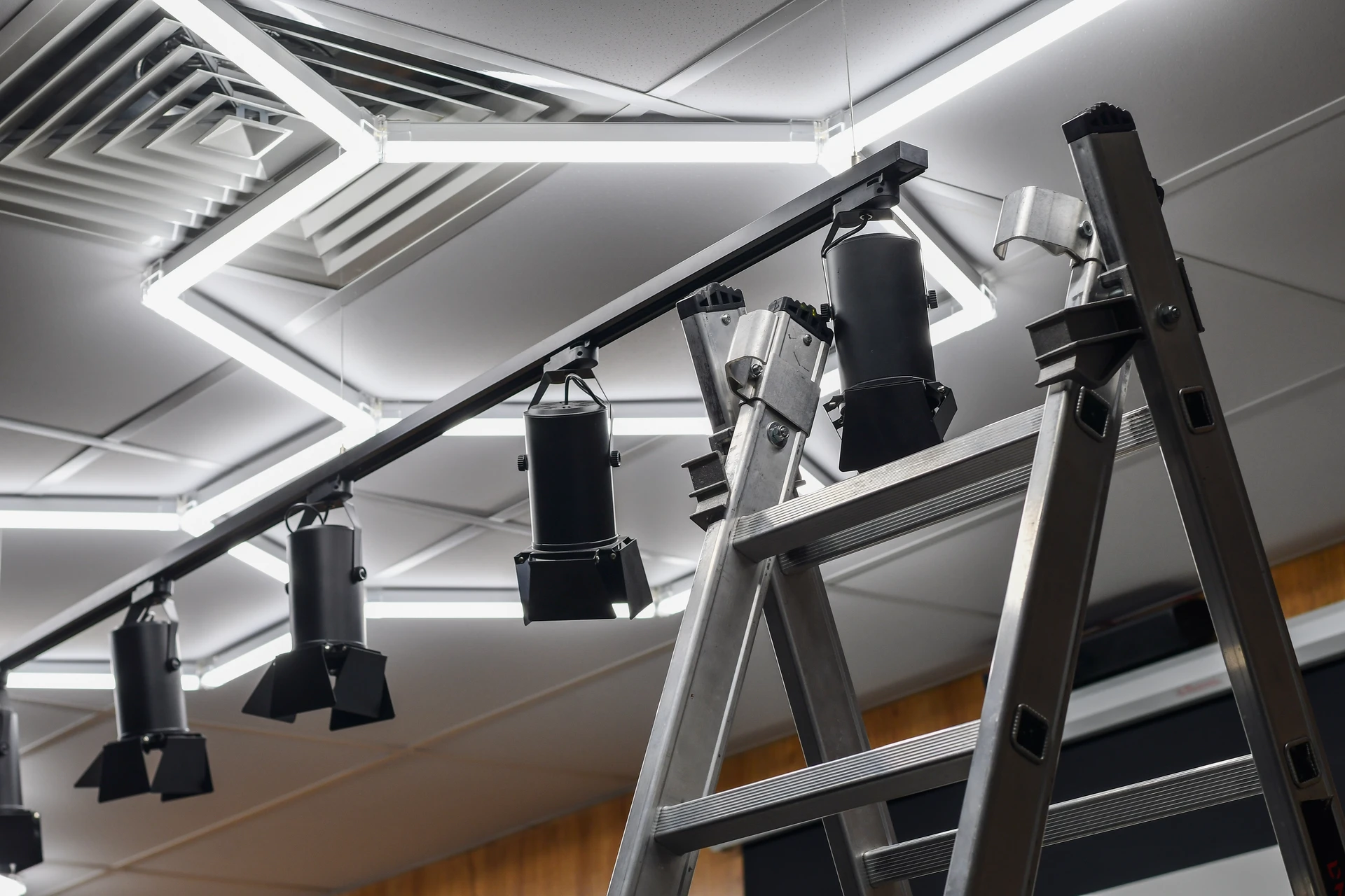 Intérieur de bureau moderne avec plafond suspendu noir intégrant un éclairage LED linéaire blanc continu